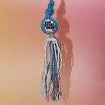The blue Retro Disco Ball Macrame Car Charm on a pink background.