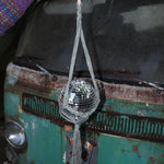 Someone holding the sage Disco Ball Hanger with Disco Ball in front of a vintage teal Volkswagen bus.