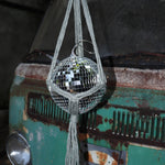 Someone holding the sage Disco Ball Hanger with Disco Ball in front of a vintage teal Volkswagen bus.