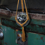 Someone holding the Mustard Disco Ball Hanger with Disco Ball in front of a vintage teal Volkswagen bus.