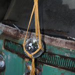 Someone holding the Mustard Disco Ball Hanger with Disco Ball in front of a vintage teal Volkswagen bus.