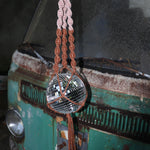 Someone holding the blush and rust Color Dip Disco Ball Hanger - Macrame Plant Hanger in front of a vintage teal Volkswagen bus.