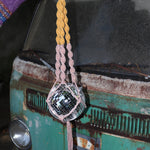 Someone holding the blush and mustard Color Dip Disco Ball Hanger - Macrame Plant Hanger in front of a vintage teal Volkswagen bus.
