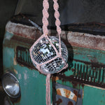 Someone holding the blush and mustard Color Dip Disco Ball Hanger - Macrame Plant Hanger in front of a vintage teal Volkswagen bus.