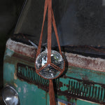 Someone holding the Rust Disco Ball Hanger with Disco Ball in front of a rusted teal Volkswagen bus.