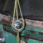 Someone holding the Chartreuse Disco Ball Hanger with Disco Ball in front of a vintage teal Volkswagen bus.