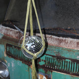 Someone holding the Chartreuse Disco Ball Hanger with Disco Ball in front of a vintage teal Volkswagen bus.