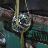 Someone holding the Chartreuse Disco Ball Hanger with Disco Ball in front of a vintage teal Volkswagen bus.