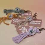 All of the Mini Macrame Disco Ball Keychain on a pink and yellow background.