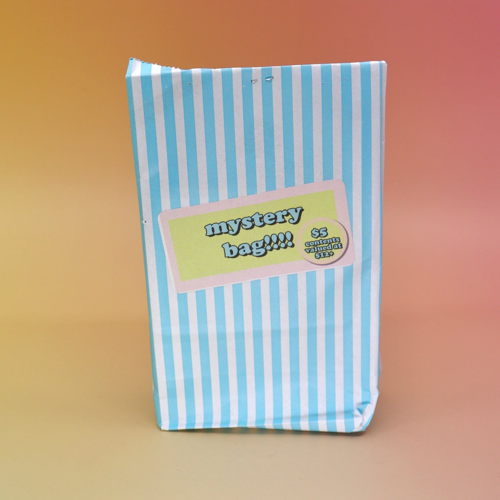 The 5 Dollar Blind Mystery Bag on a pink and orange background.