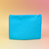The back of the Me & My Lip Products Against The World Canvas Zipper Pouch on a pink and yellow background.