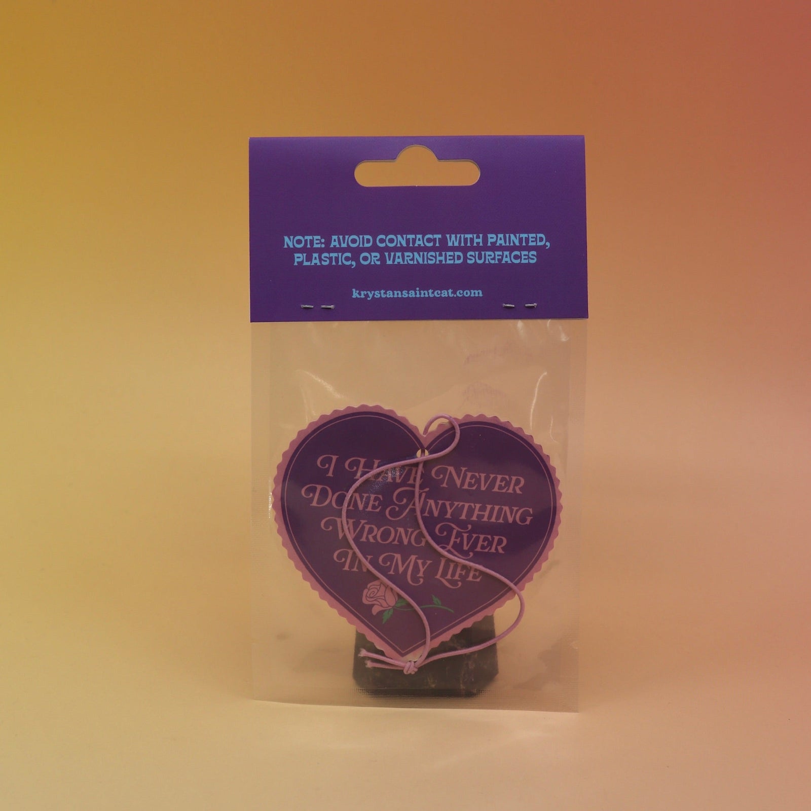 The back of the I Have Never Done Anything Wrong - Candy Scented Air Freshener on a pink and yellow background.