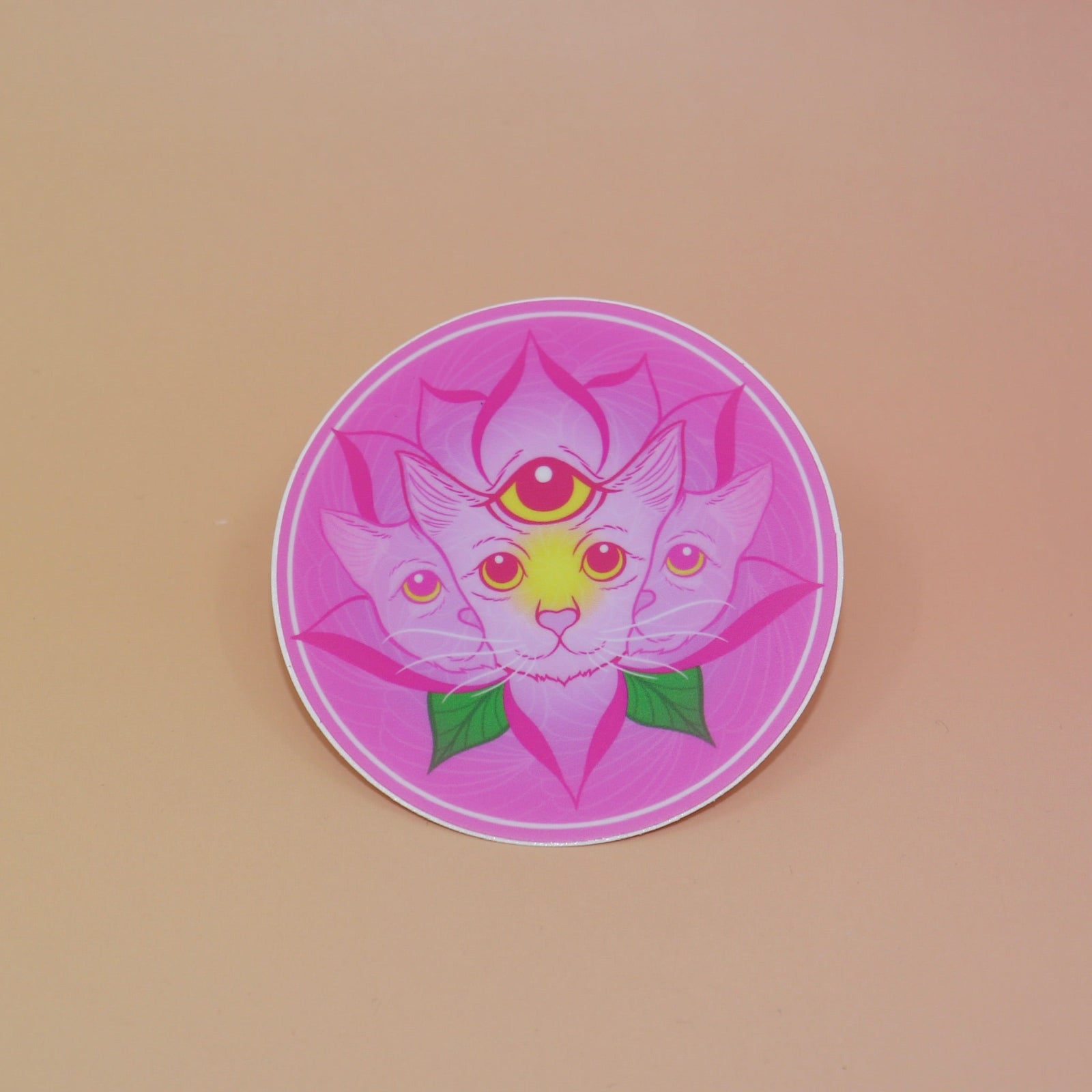The Four Eared Lotus 3” Round Vinyl Sticker on a light pink background.