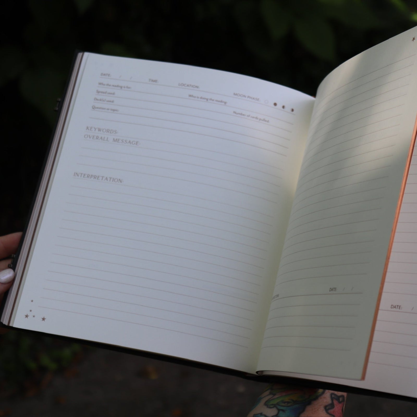 A woman holding the Complete Tarot & Oracle Journal Hardcover Book open to show off the pages.