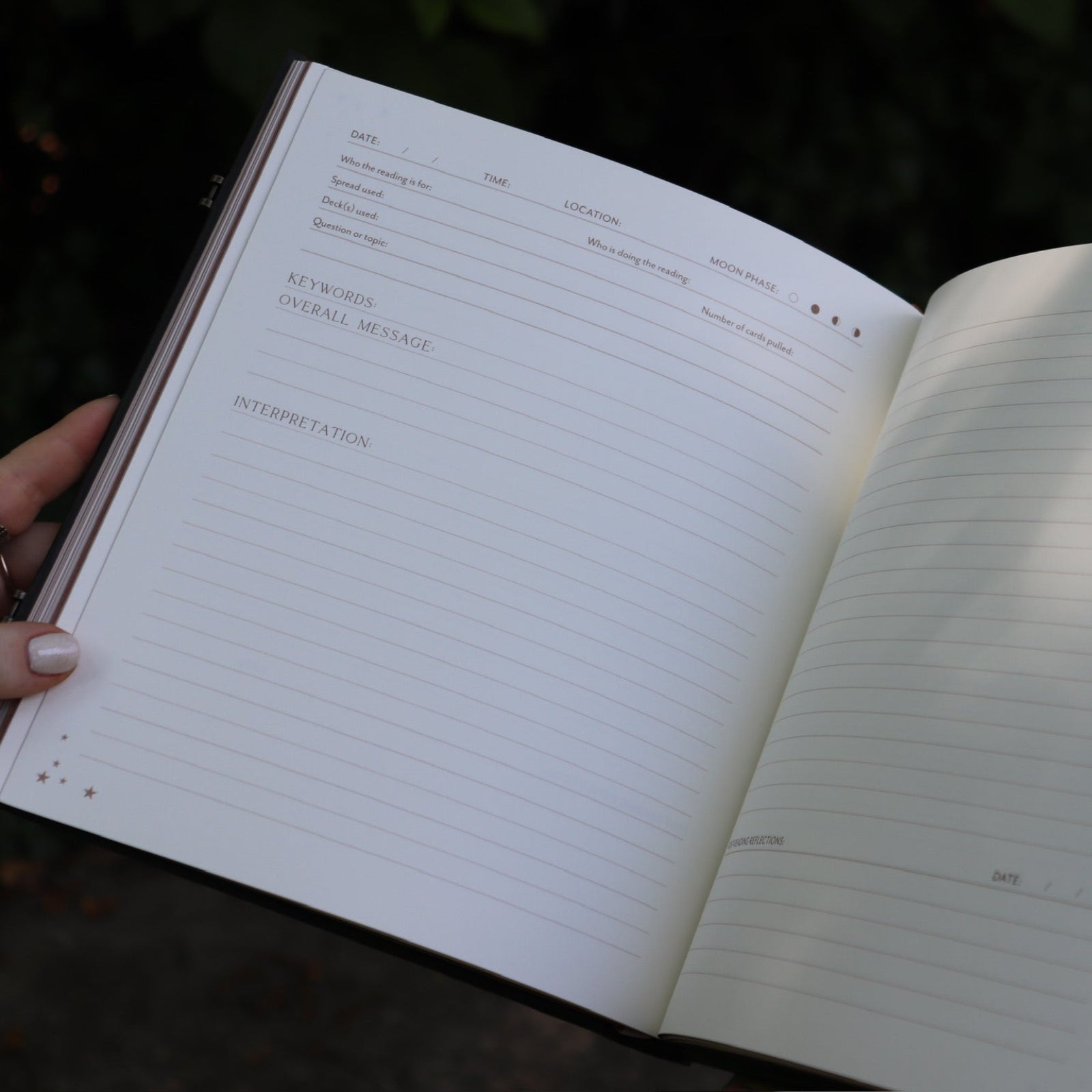 A woman holding the Complete Tarot & Oracle Journal Hardcover Book open to show off the pages.