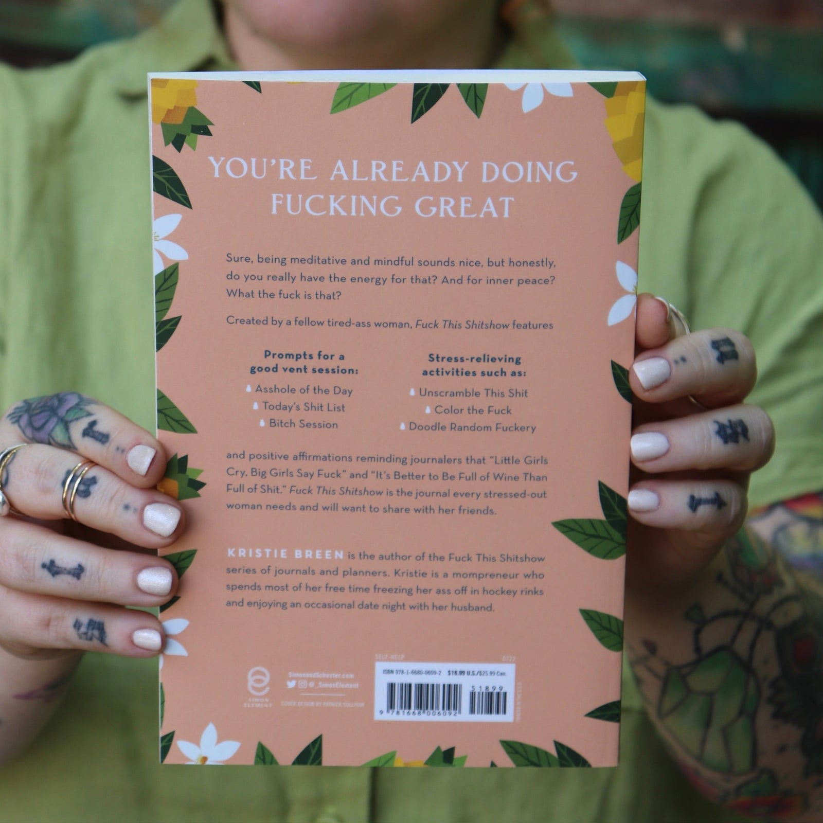 Someone holding the F*ck This Sh*tshow Gratitude Journal.