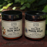 The Golden Moon Milk - 5oz Blue Lotus Vanilla Powder and Golden Sun Milk Powder on a red surface next to ivy.