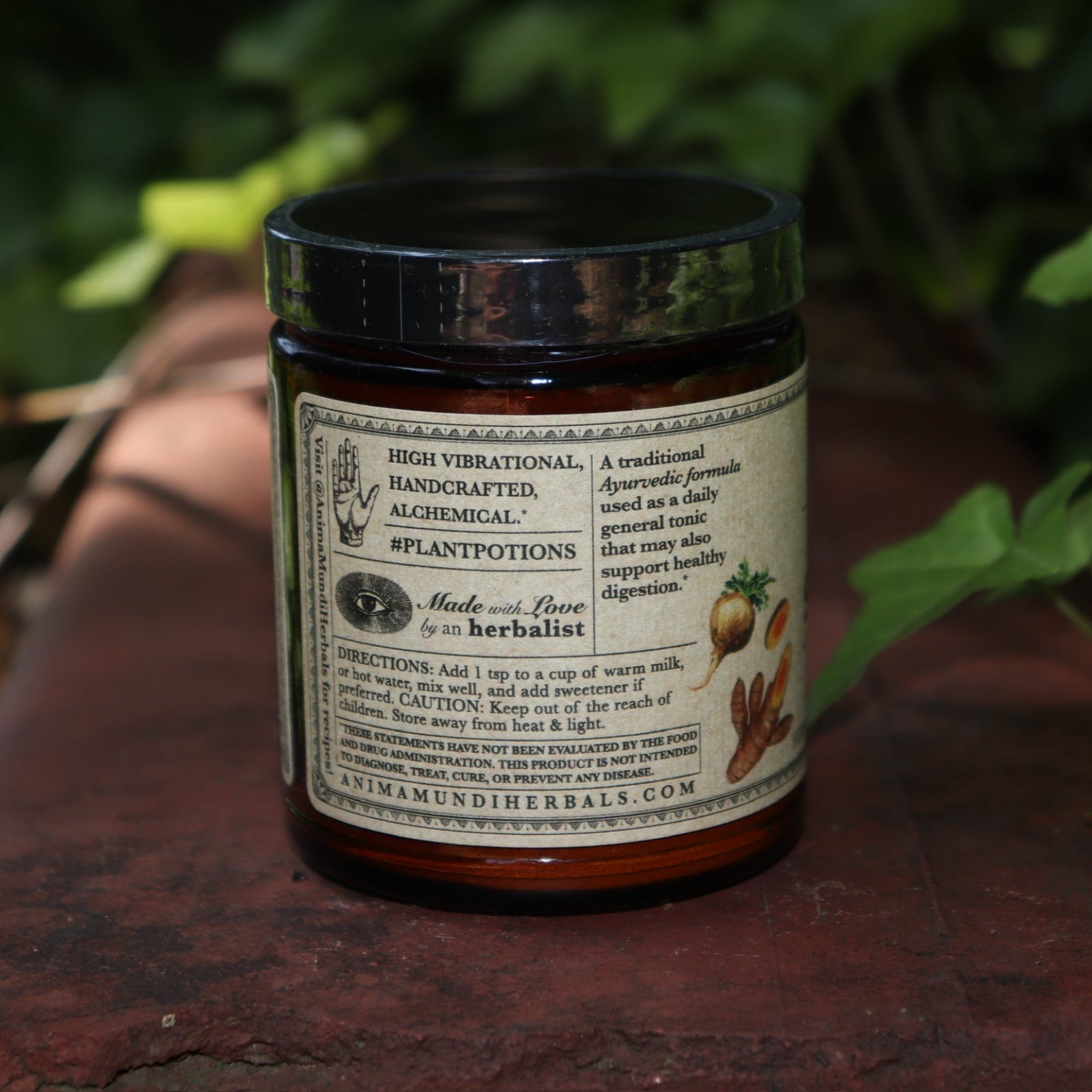 The side of the Golden Sun Milk - 5oz Energizing Adaptogenic Chai Powder on a red surface next to ivy.