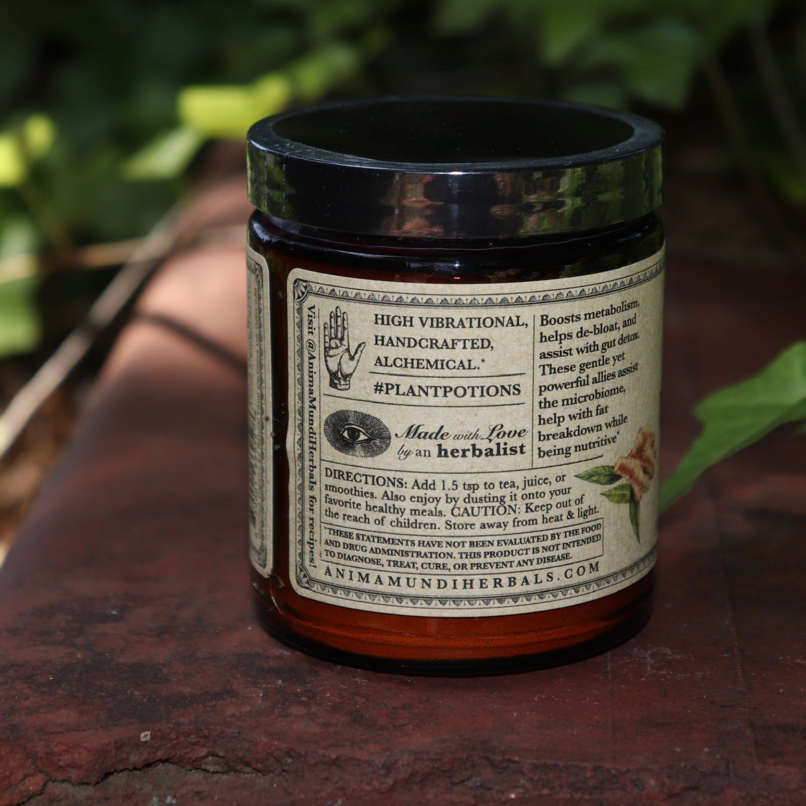 The side of the Belly Love - Metabolism Harmonizer 4.5 oz Powder on a rusty red surface surrounded by green ivy.