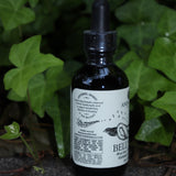 The Belly Love - 2oz Metabolism + Digestive Support Tonic in front of ivy.