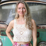 A woman wearing the beige Handmade Vintage Crochet Design Camisole with tie-dye bottoms.
