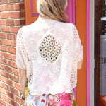 A woman wearing the beige Lace Open Front Cardigan with Batwing Sleeves with tie-dye bottoms and top.