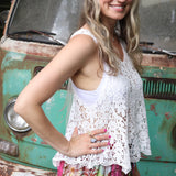 A woman wearing the white Crochet Hollow Knit Vest with Leaf Texture with tie-dye bottoms.