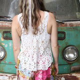 A woman wearing the white Crochet Hollow Knit Vest with Leaf Texture with tie-dye bottoms.