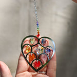 Someone holding the Heart of Hearts Chakra Ornament in the sunlight.