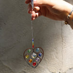 Someone holding the Heart of Hearts Chakra Ornament in the sunlight.