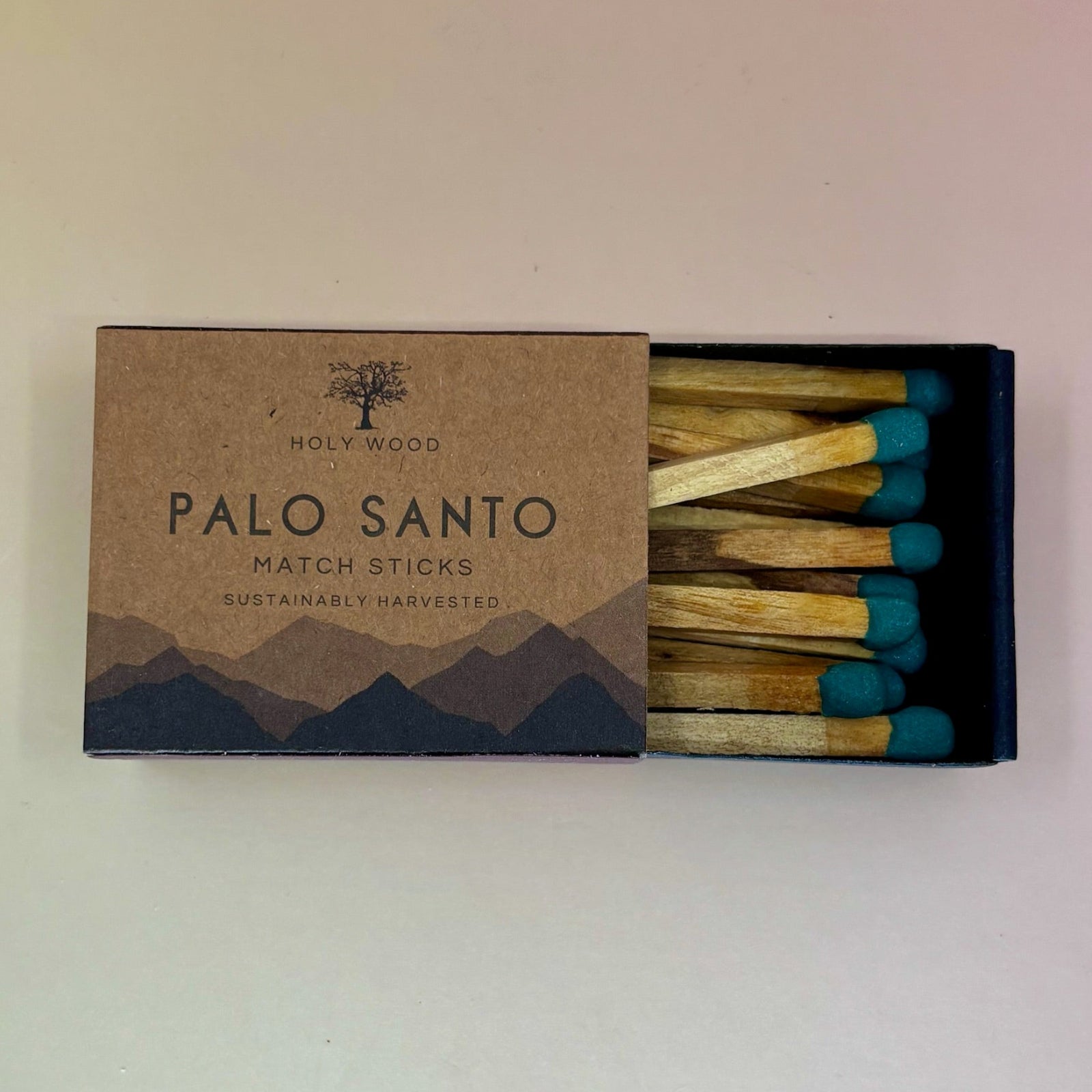 The Palo Santo Matchsticks on a pale pink and yellow background.