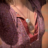 Someone wearing the Crystal Ball Necklace in Copper - Clear Quartz.