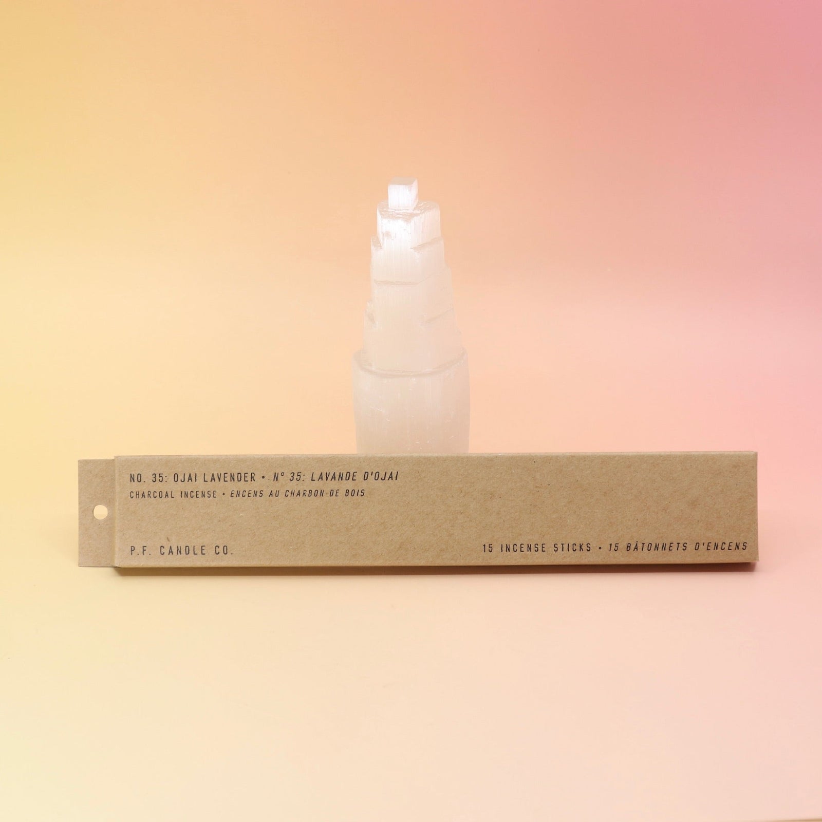 The P.F. Candle Co. Ojai Lavender - Incense in front of a selenite tower all on a pink and yellow background.