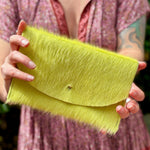 Someone holding the Chartreuse Hair on Hide Envelop Pouch Clutch.
