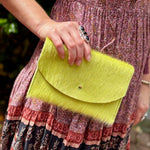 Someone holding the Chartreuse Hair on Hide Envelop Pouch Clutch.