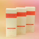 The Smoked Cherry, Plush Vetiver, and Blonde Hinoki reed diffusers next to each other on a pink and yellow background.