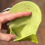 Someone holding the Chartreuse Leather Cardholder open to show the inside.