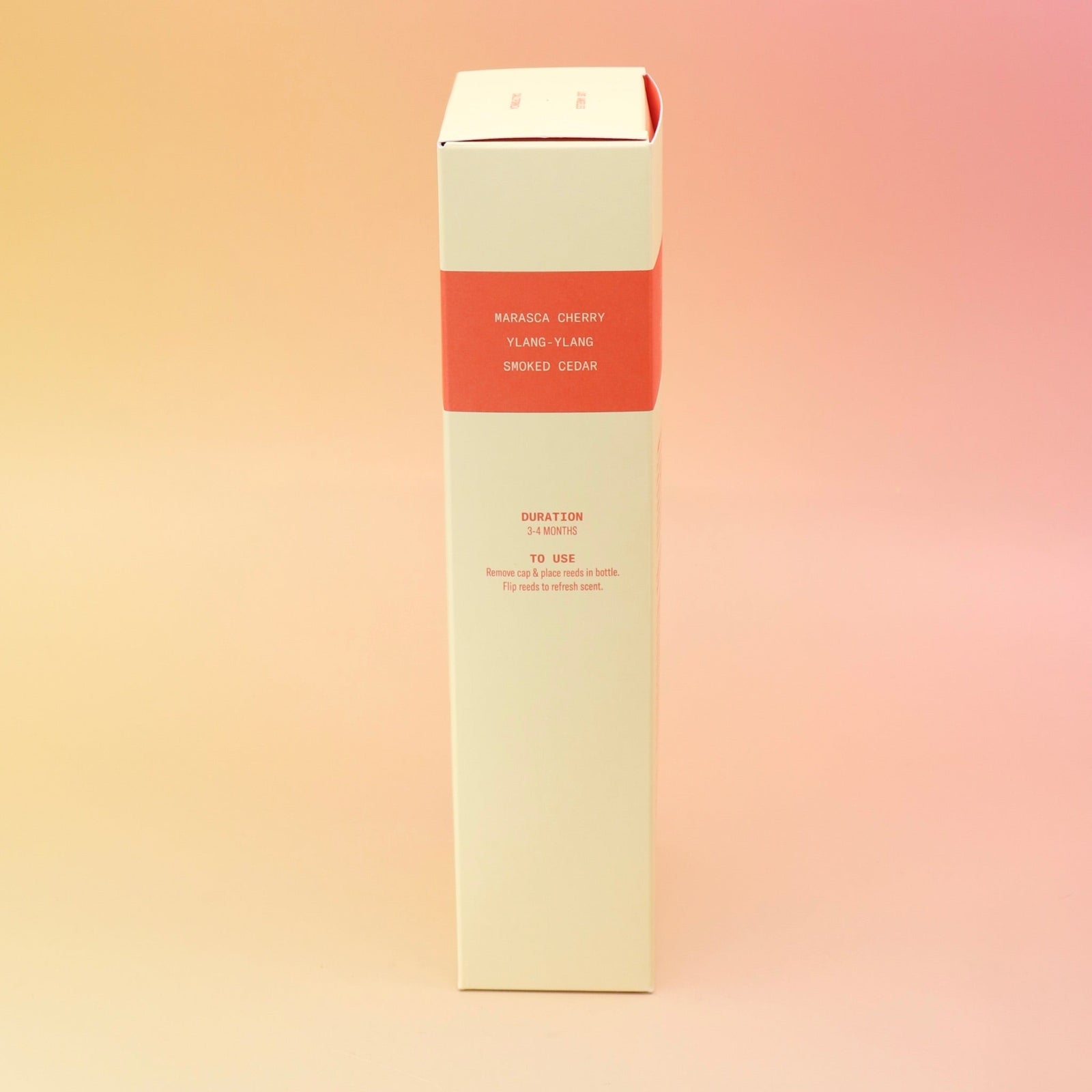 The side of the Smoked Cherry – HI-FI Reed Diffuser box on a pink and yellow background.
