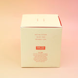 The side of the Plush Vetiver - HI-FI Soy Wax Candle box on a pink and yellow background.