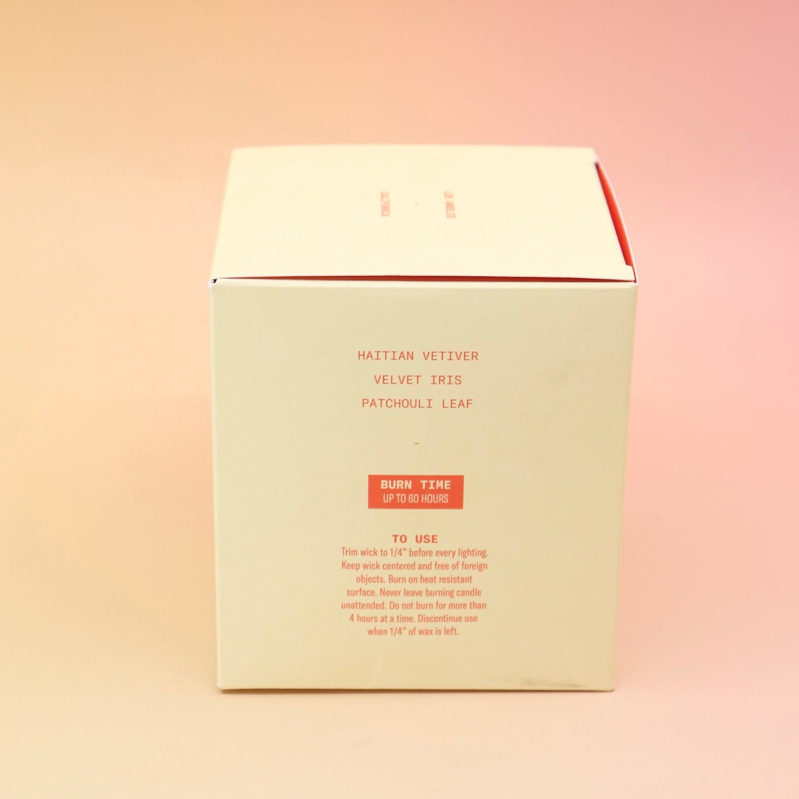 The side of the Plush Vetiver - HI-FI Soy Wax Candle box on a pink and yellow background.