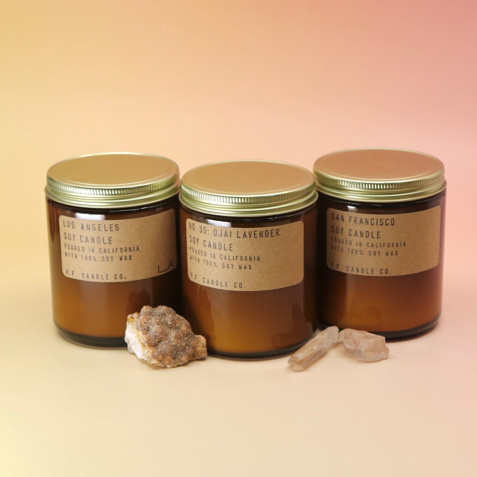 The candles from the P.F. Candle Co. - California Classics Gift Set on a pink and yellow background.