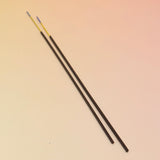The Lammas Premium Floral Charcoal Incense sticks on a pink and yellow background.