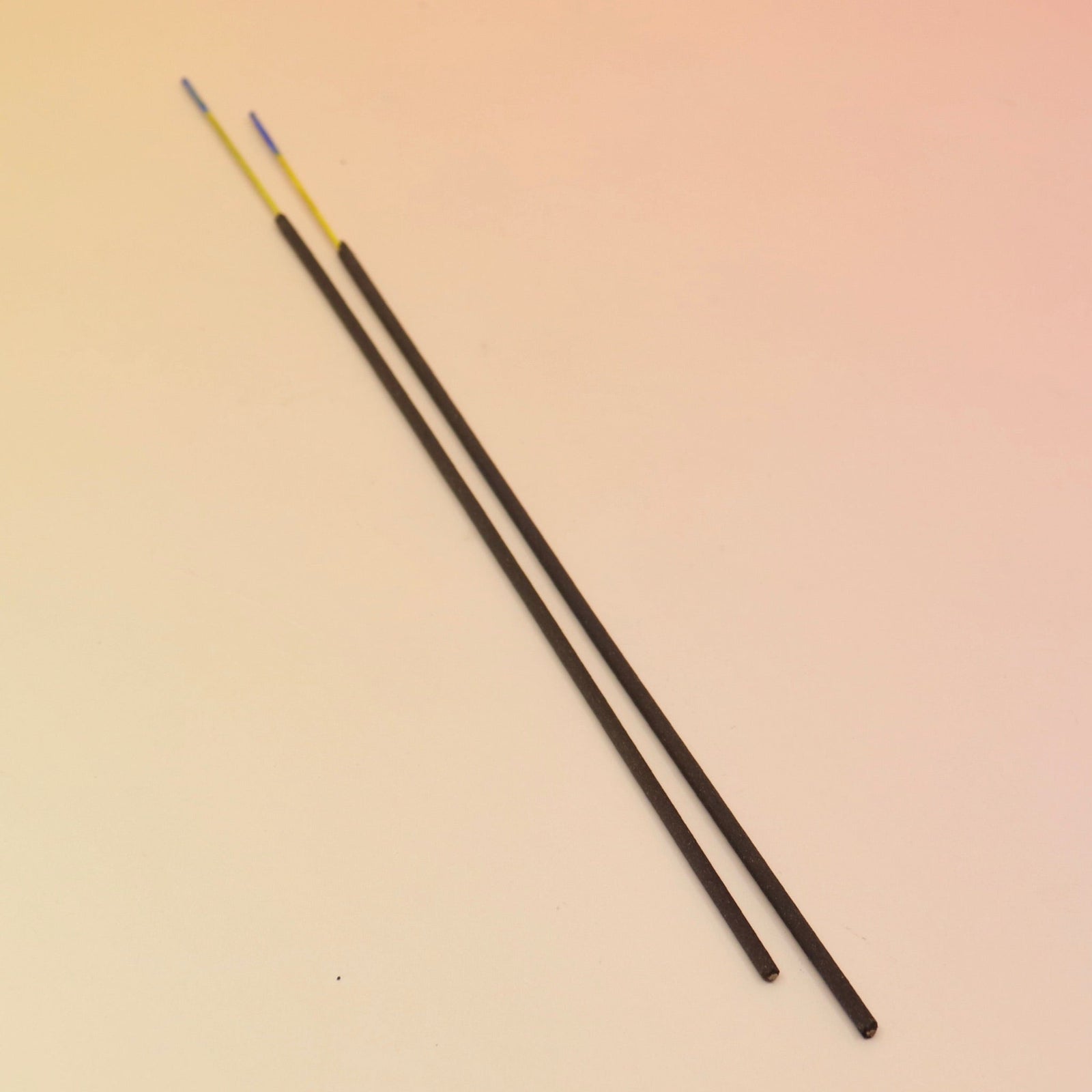 The Lammas Premium Floral Charcoal Incense sticks on a pink and yellow background.