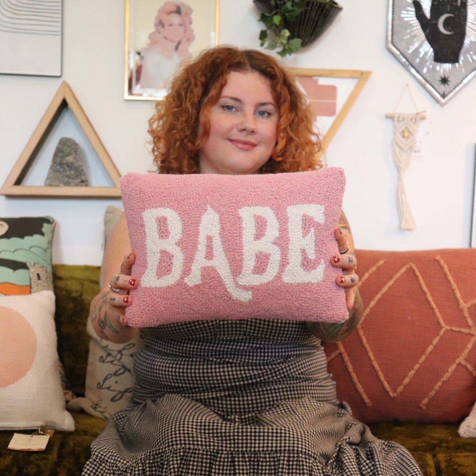 A woman holding the Babe Wool Hook Pillow.