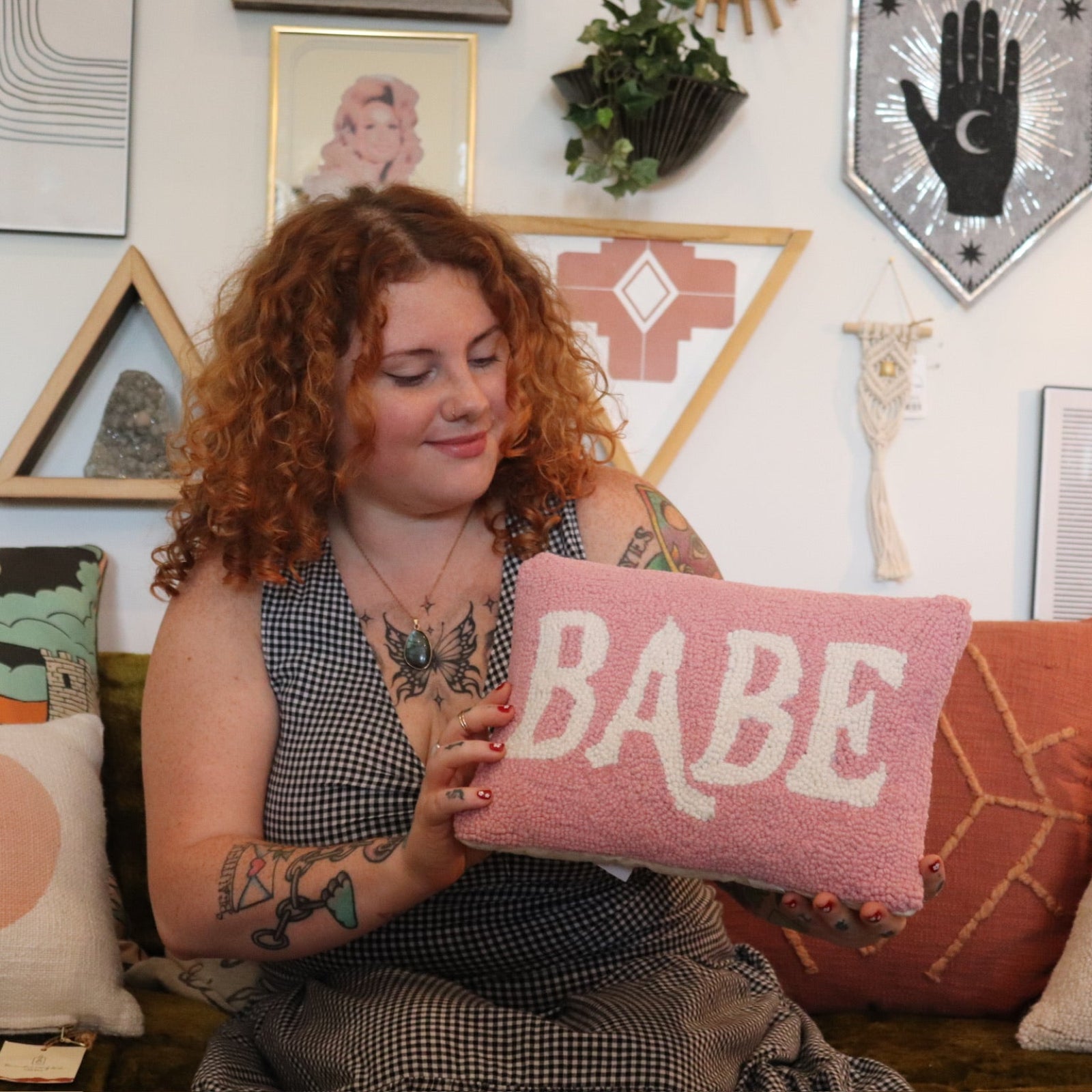 A woman holding the Babe Wool Hook Pillow.