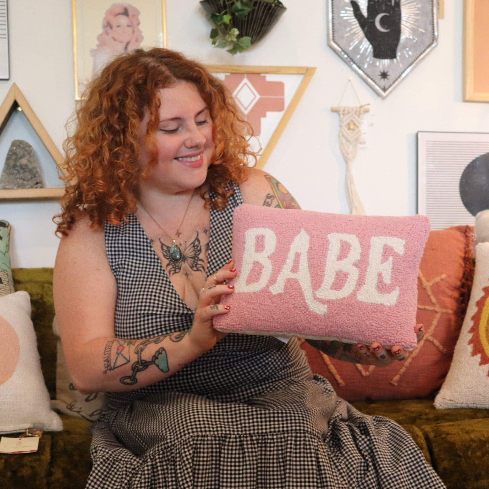 A woman holding the Babe Wool Hook Pillow.