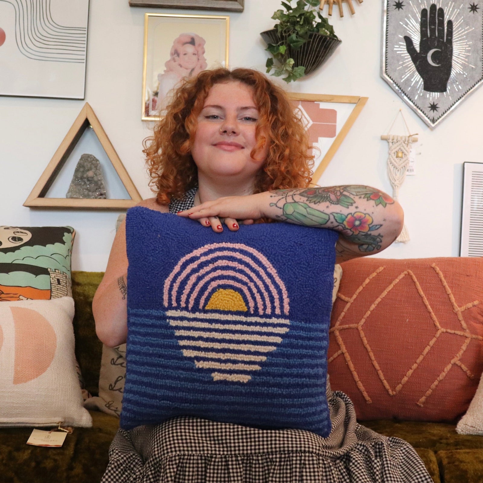 A woman holding the Blue Sunset Hook Pillow.