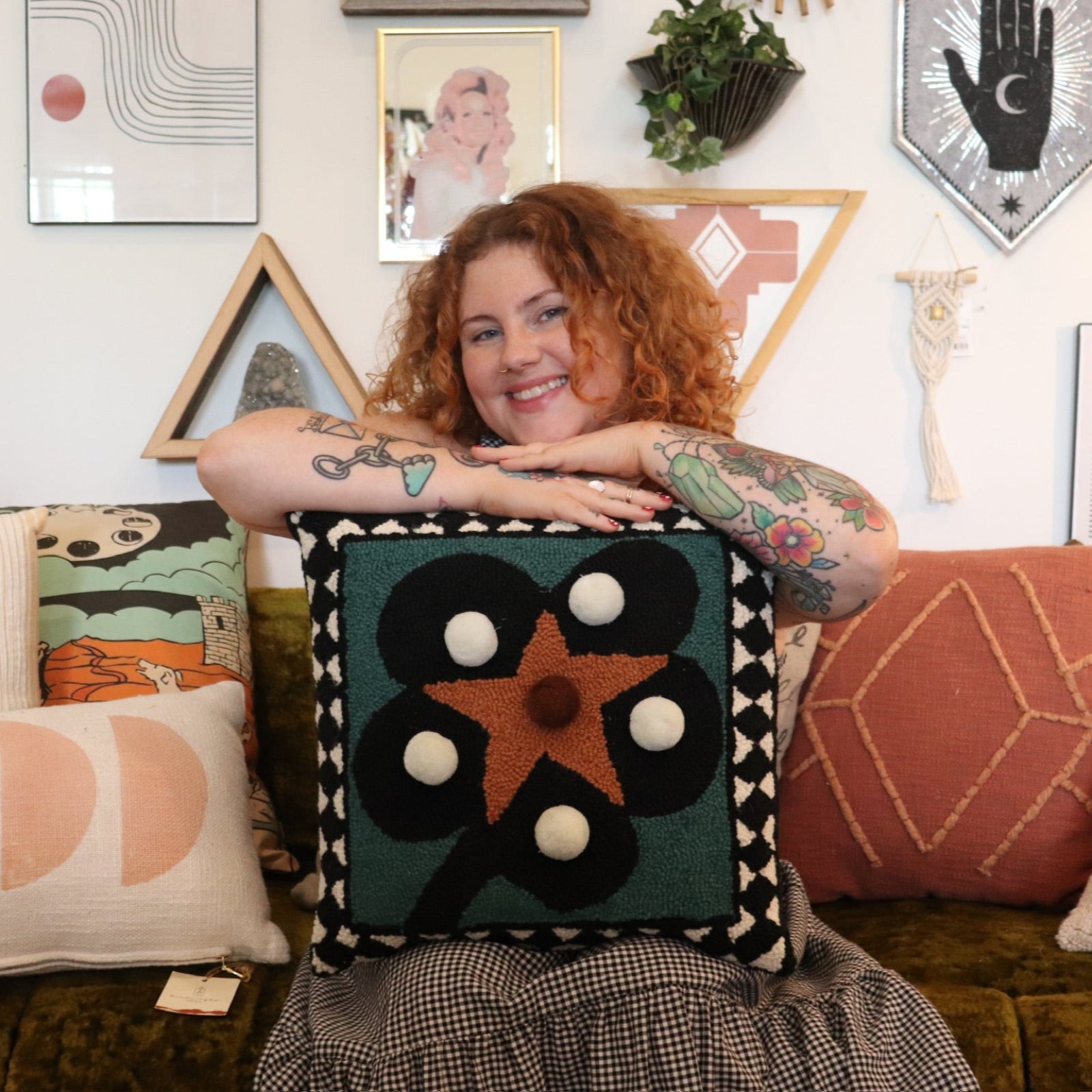 A woman holding theDiamonds & Pearls with Pom Poms Wool Hook Pillow.