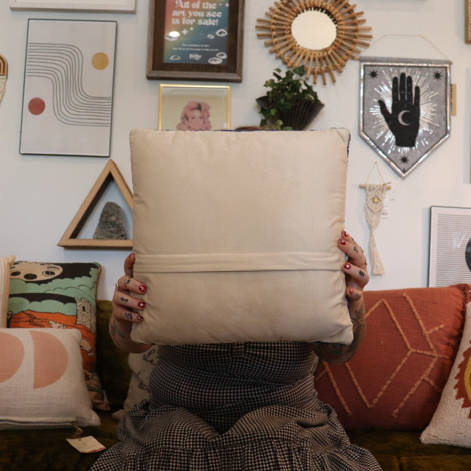 A woman holding the 'Stay Groovy' Wool Hook Pillow.