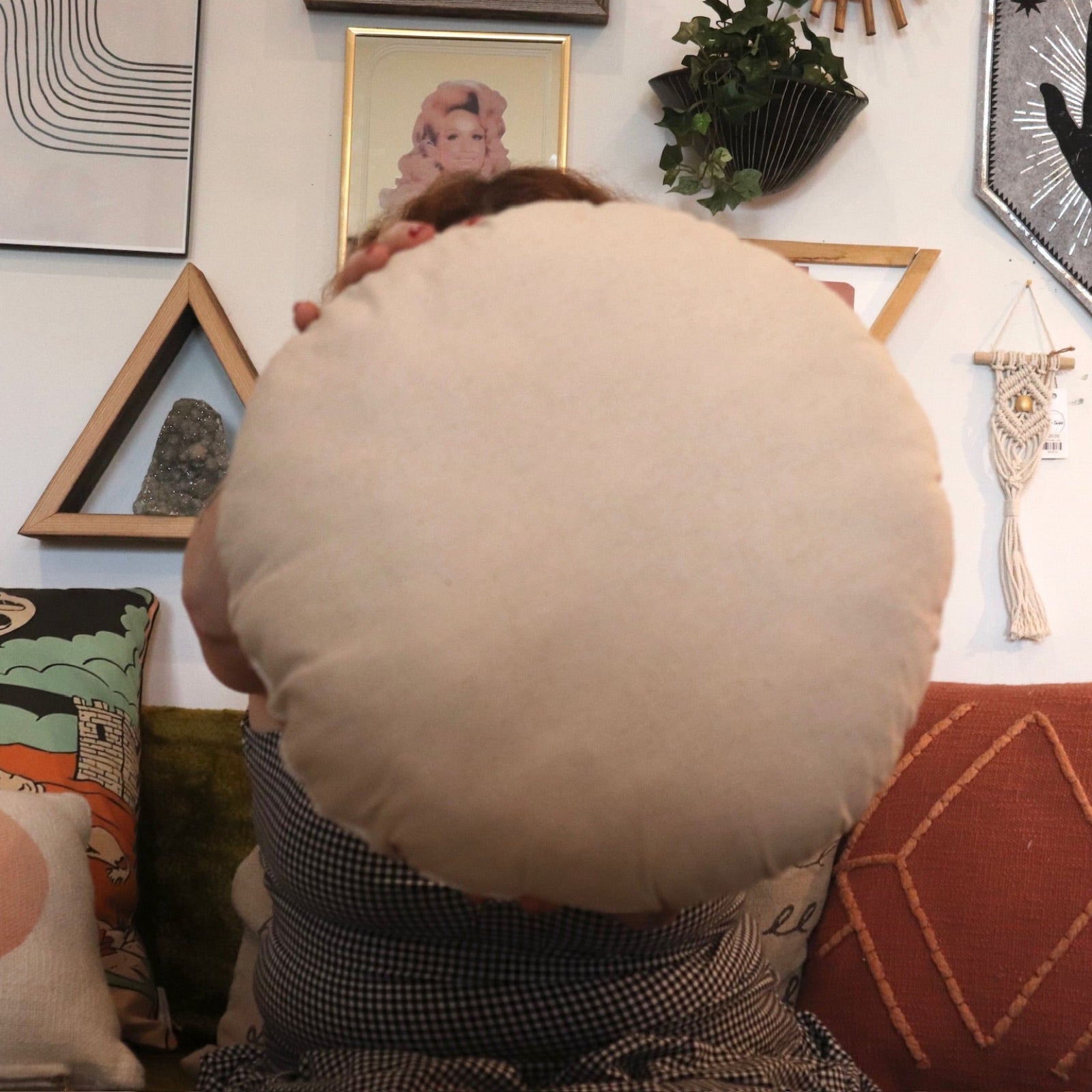 A woman holding the Ayo Sunshine Embroidered Decorative Pillow.